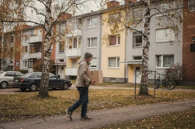 Kerrostaloja ja jalankulkijoita suomalaisella asuinalueella.